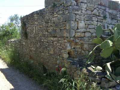Una veduta laterale della torre costeggiata da una strada sterrata